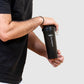 man shaking the protein shaker for a post workout meal. 