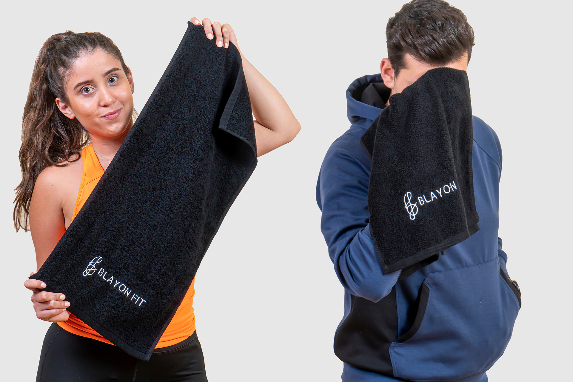 a gir and guy holding gym towel to wipe their sweat
