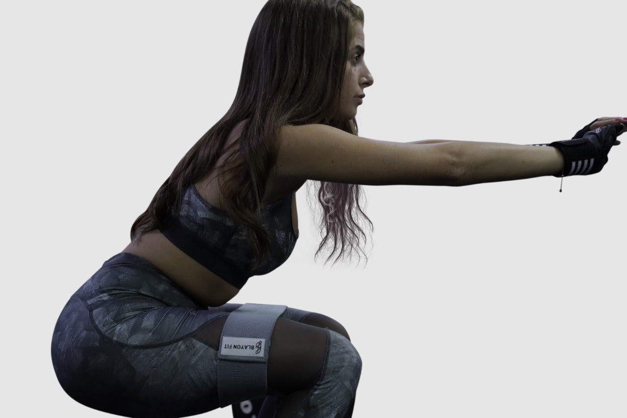 woman using fabric resistant bands for female home workout such as squats